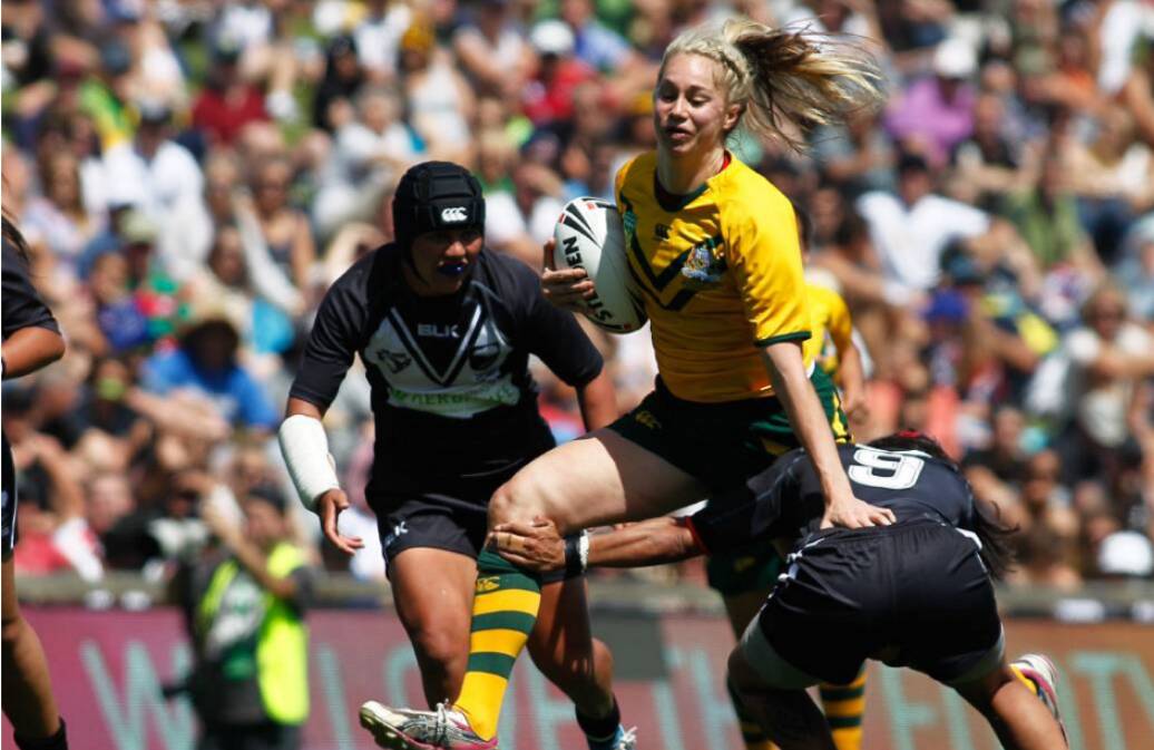 Hard runner: Kezie Apps charges through a tackle by the Kiwi Ferns, with the Bega local being described by coaches as Australia’s best player. Photo: Supplied