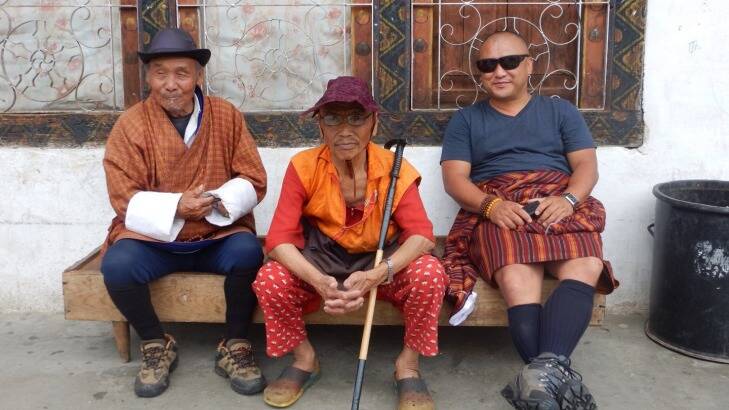 Men sit outside a house in downtown Paro, Bhutan.?? Photographer: Nick Abrahams