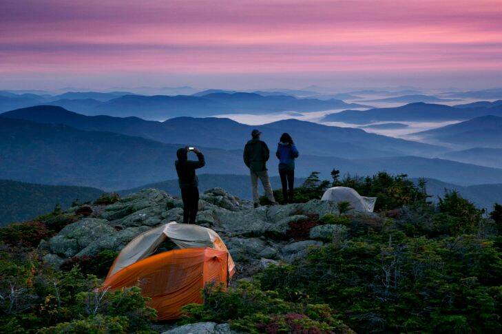 Robert Weiss of Tewksbury, Mass., left, photographs his brother-in-law, Matthew Ferri, of Dracut, Mass., and his wife, Andrea Weiss just before sunrise from their campsite on the Appalachian Trail in Beans Purchase, N.H., Sunday, Sept. 17, 2017. The backpackers were taking advantage of pleasant weather to get in some hiking on the final weekend of summer. (AP Photo/Robert F. Bukaty)