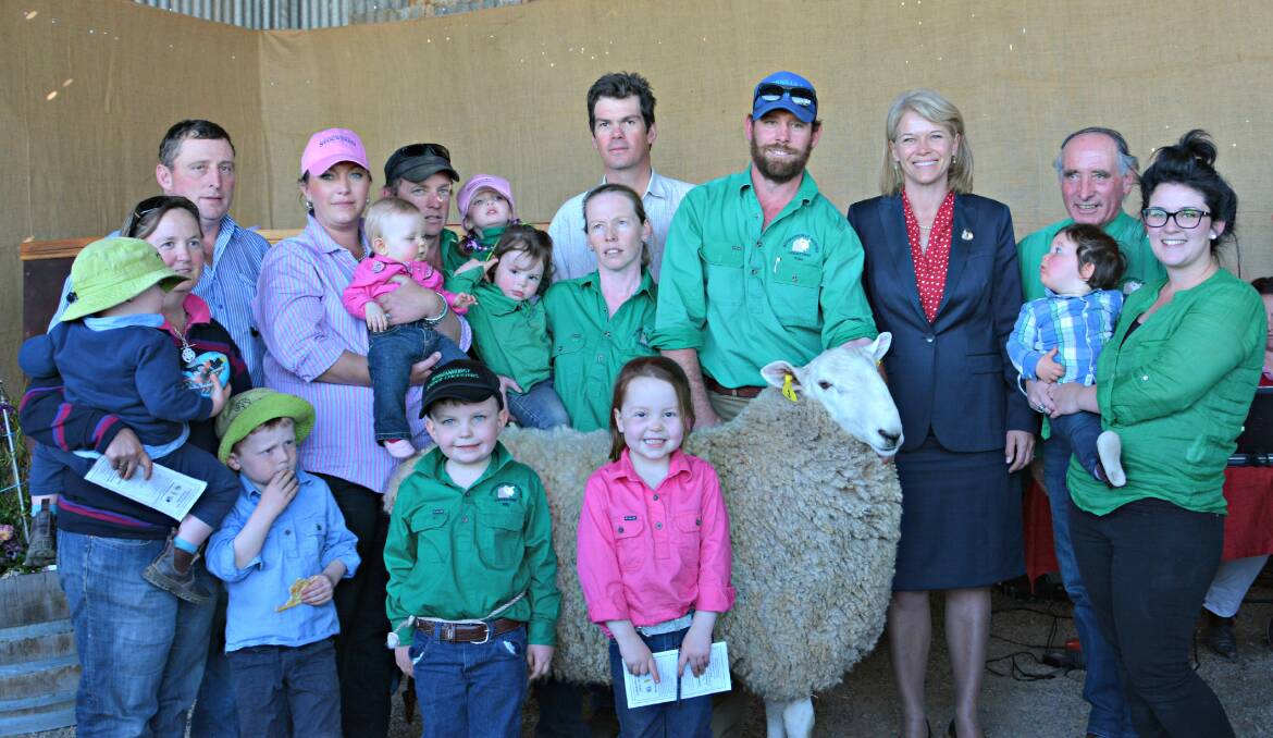 REASON TO CELEBRATE: NSW Minister Agriculture and Member for Burrinjuck Katrina Hodgkinson with Normanhurst Stud Principal Michael Corkhill (back right), sons Michael junior, Ashley and Tom Corkhill and Catherine Culley with their families around the top priced ram, Normanhurst’s Sydney Royal Easter Show Junior Champion Ram at the 50th anniversary sale. (Absent Julie Schofield and her family) (Photo by Margot Shannon.)