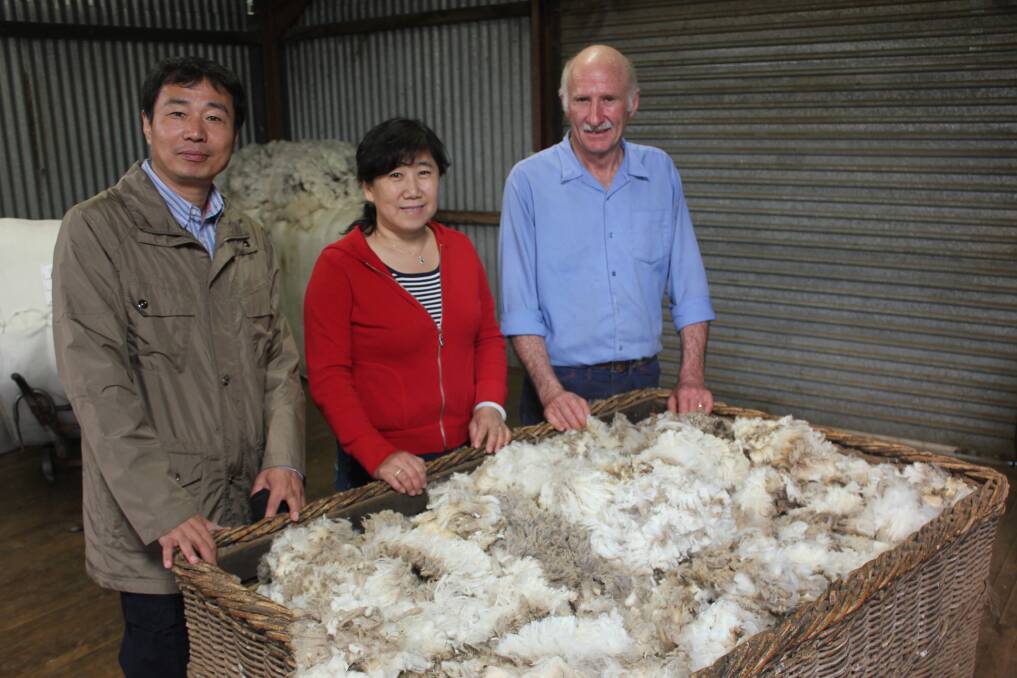 INSPECTING: Mr Li Dong and Madame Huang Shu Yuan from the Chinese Wool and Textile Industry inspect Bungonia wool producer Phillip Broadhead’s freshly shorn fleeces for quality. The Broadhead’s wool is normally around 18-18.5 micron thickness. (Photo: ANTONY DUBBER.)