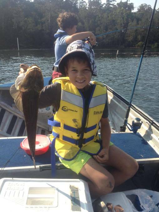 Daniel Betts and his first ever legal-size flathead catch, a beauty at 54cm, caught on Wagonga Inlet on Saturday thanks to Scott and Tom taking him out. 