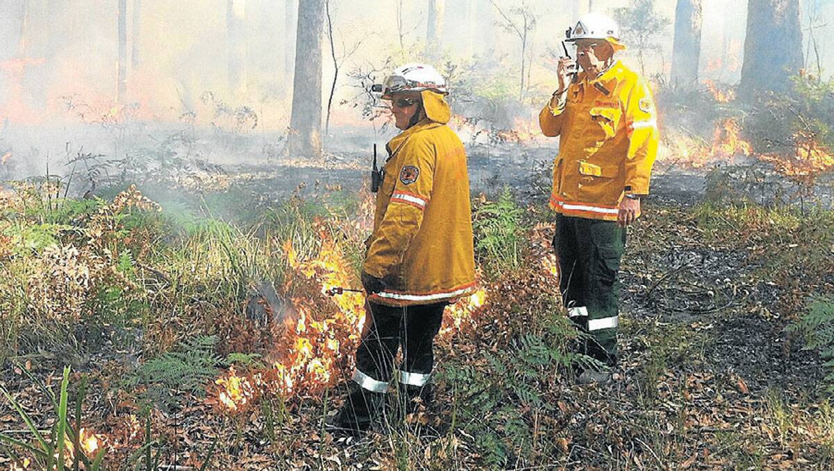 NOT TOO HOT: NPWS Field Officer Ron Rutter and Field Supervisor Pat Keegan conducting a low intensity, hazard reduction burn under near ideal conditions in Murramarang National Park last Week. Photo by NPWS.