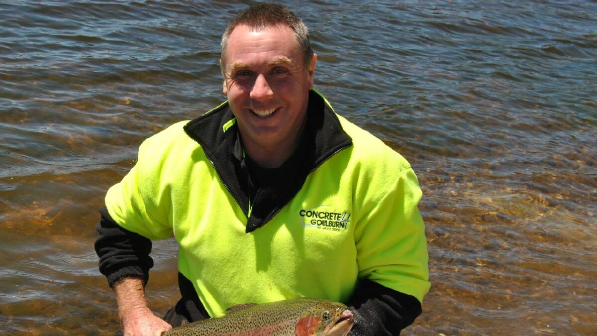 GOOD CATCH: Cr Andrew Banfield from Goulburn Mulwaree Council  pictured with one of the massive rainbow trout that were released into Pejar Dam in 2014.   