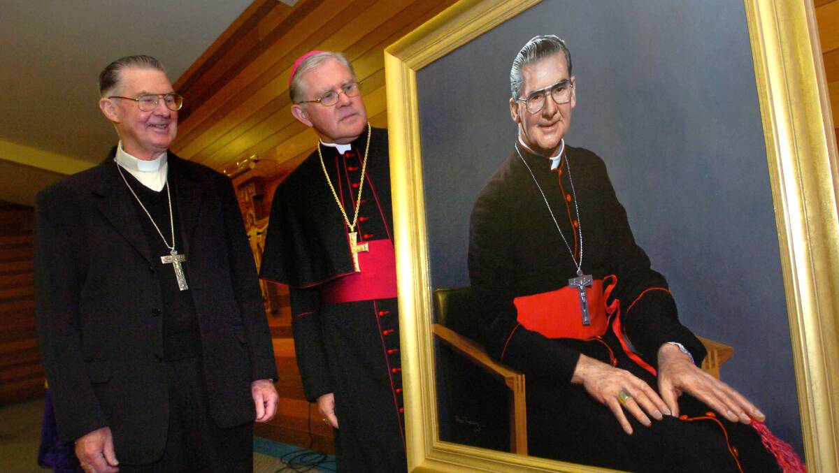 Former Archbishop of Canberra and Goulburn, Francis Carroll, left, admires his portrait with his successor Archbishop Mark Coleridge in 2007. It was painted by artist Ross Townsend. Picture by Richard Briggs