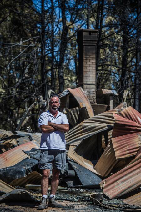 GONE: Scott Williams counted the cost to Richard Graham's Hazeldell Road log cabin after the Currandooley fire destroyed it in January, 2017. Photo: Karleen Minney.