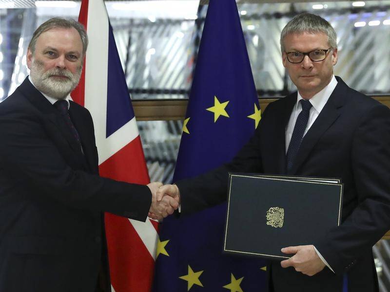 Britain's EU ambassador Tim Barrow (L) has handed Brexit documents to the European Commission.