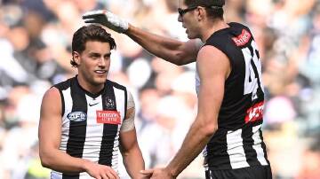Magpie Mason Cox (right) congratulates Patrick Lipinski on one of his four goals against Port. (James Ross/AAP PHOTOS)