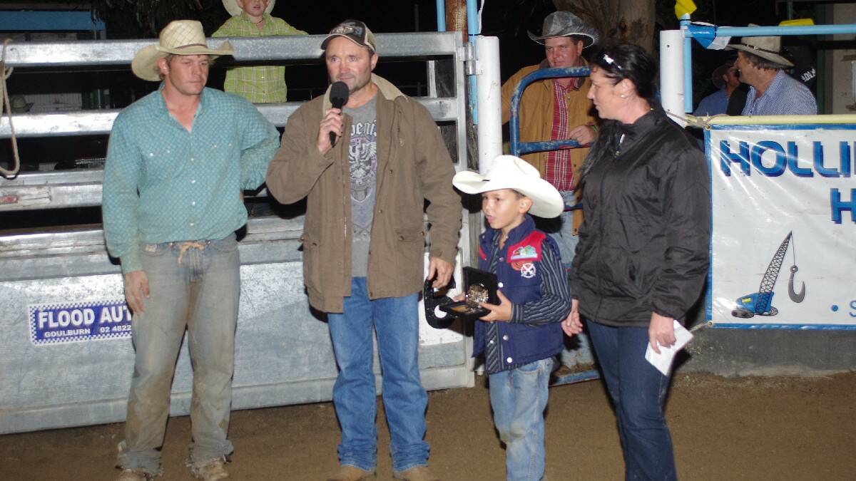 Tim Amey speaks to Ralph, Cooper and Rebecca Burch after the Ben Burch Memorial Buckle bull ride. 