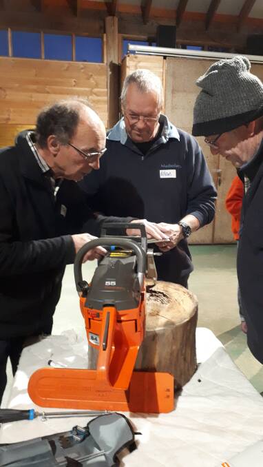 DEMONSTRATION: Allan Spencer (middle) demonstrates to participant Paolo how to sharpen a chainsaw. Photo: Supplied