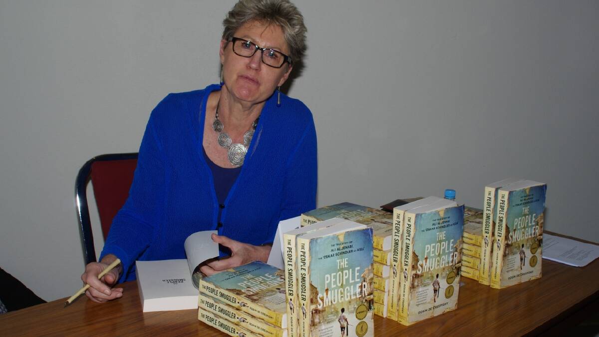 Author Robin de Crespigny with copies her book ‘The People Smuggler’.